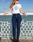 young woman wearing white t-shirt and blue jeans leaning on the bridge