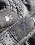 Close-up of gray leather shoes with paw print designs on the soles.