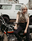 A woman siting on a motorcycle wearing black cargo pants Lara from Moto Girl