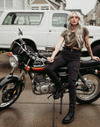 A woman siting on a motorcycle wearing black cargo pants Lara from Moto Girl