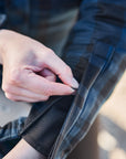 Person adjusting a zipper on a jacket with a blurred background