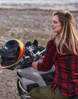 Woman sitting on a motorcycle with a helmet on a beach