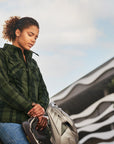 Woman holding a helmet next to a motorcycle with a scenic background