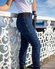 close up of woman's legs wearing blue moto jeans and black boots