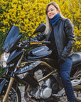 A blond woman on a motorcycle wearing black leather jacket