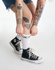 Women's tattood legs wearing white socks with "gear" motive