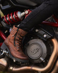 woman's foot on a motorcycle rest wearing brown leather mc boots