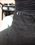 a close up of a woman's waist wearing high wait black motorcycle jeans with adjustment stripes