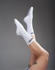 Women's legs wearing white socks with "break" and "gear"