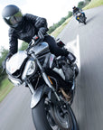 A woman driving a motorcycle wearing Black leather women's motorcycle jacket with reflectors from Moto Girl