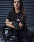 A young woman on a motorcycle leaning on a helmet