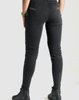 woman's legs from the back wearing black high waist motorcycle jeans