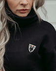 a blong young women wearing high neck black sweatshirt with motogirl logo in front