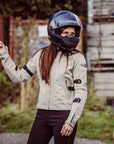 A woman with a helmet wearing women's summer mesh motorcycle jacket from Moto Girl and pointing somewhere