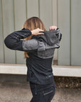 A woman putting a hood of a grey motorcycle jacket from shima