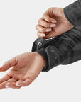 Close-up of a person wearing a dark gray plaid shirt with a focus on the sleeve and hand.