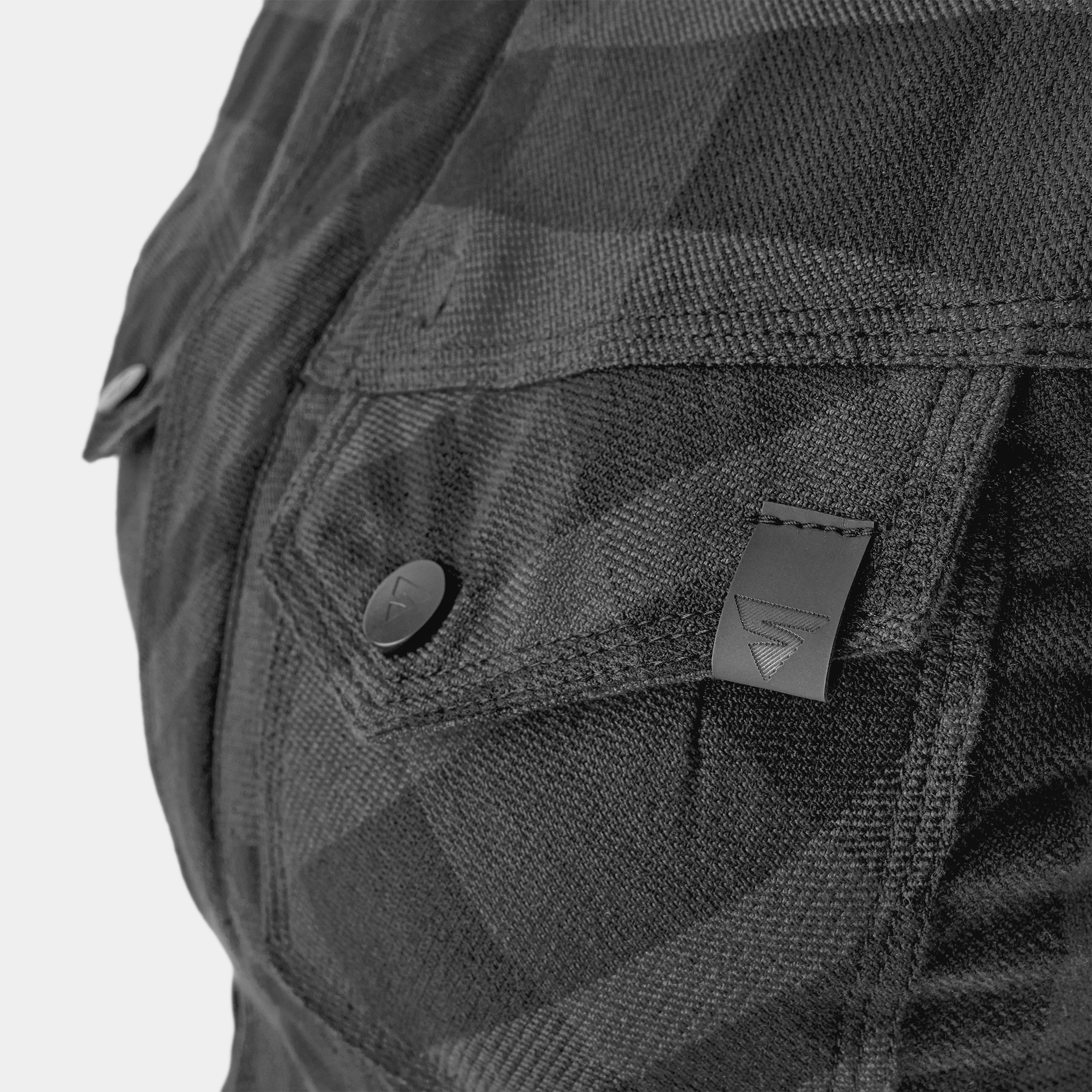 Close-up of a dark camouflage backpack with a brand logo on a light gray background