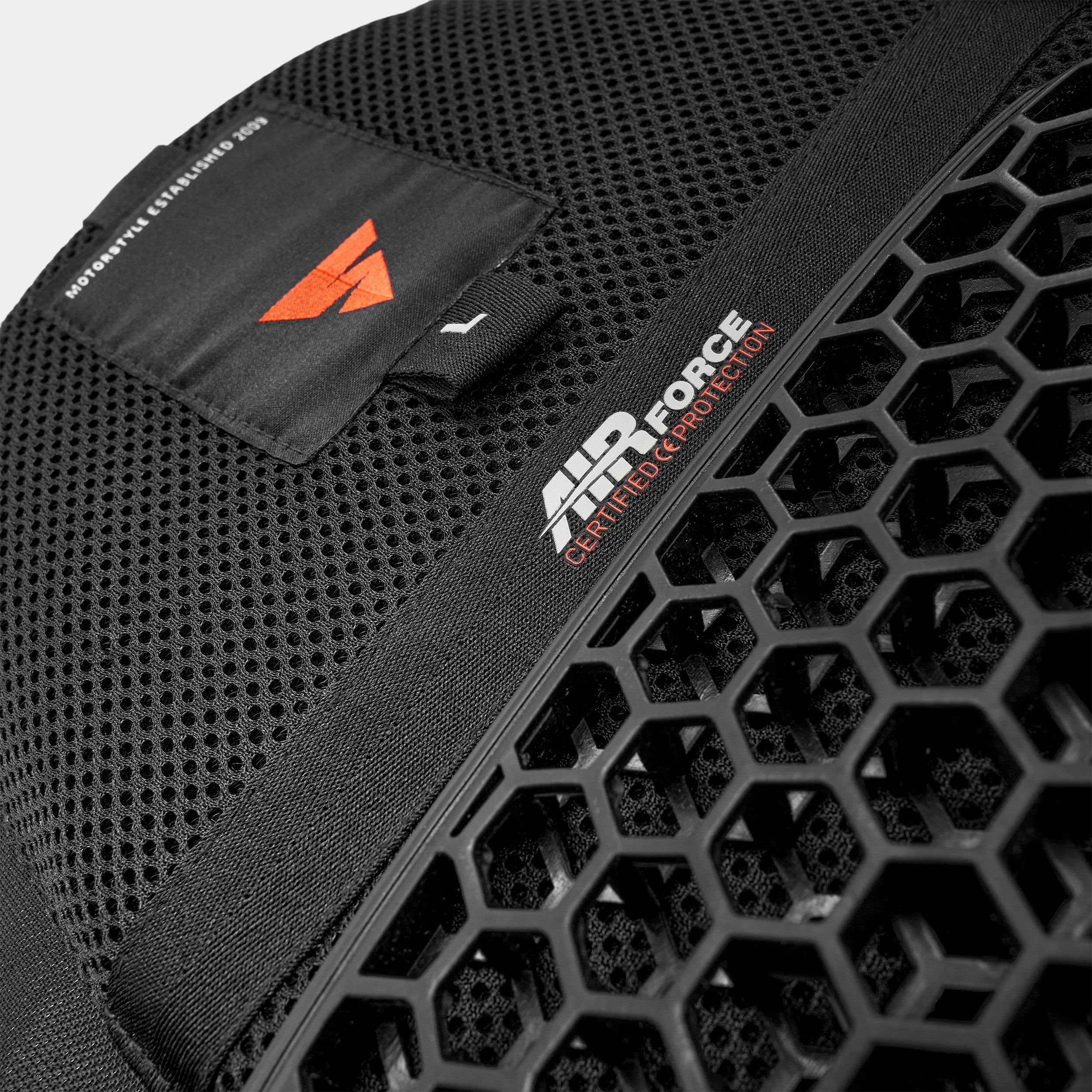 Black protective gear with honeycomb design and Air Force logo on a gray background