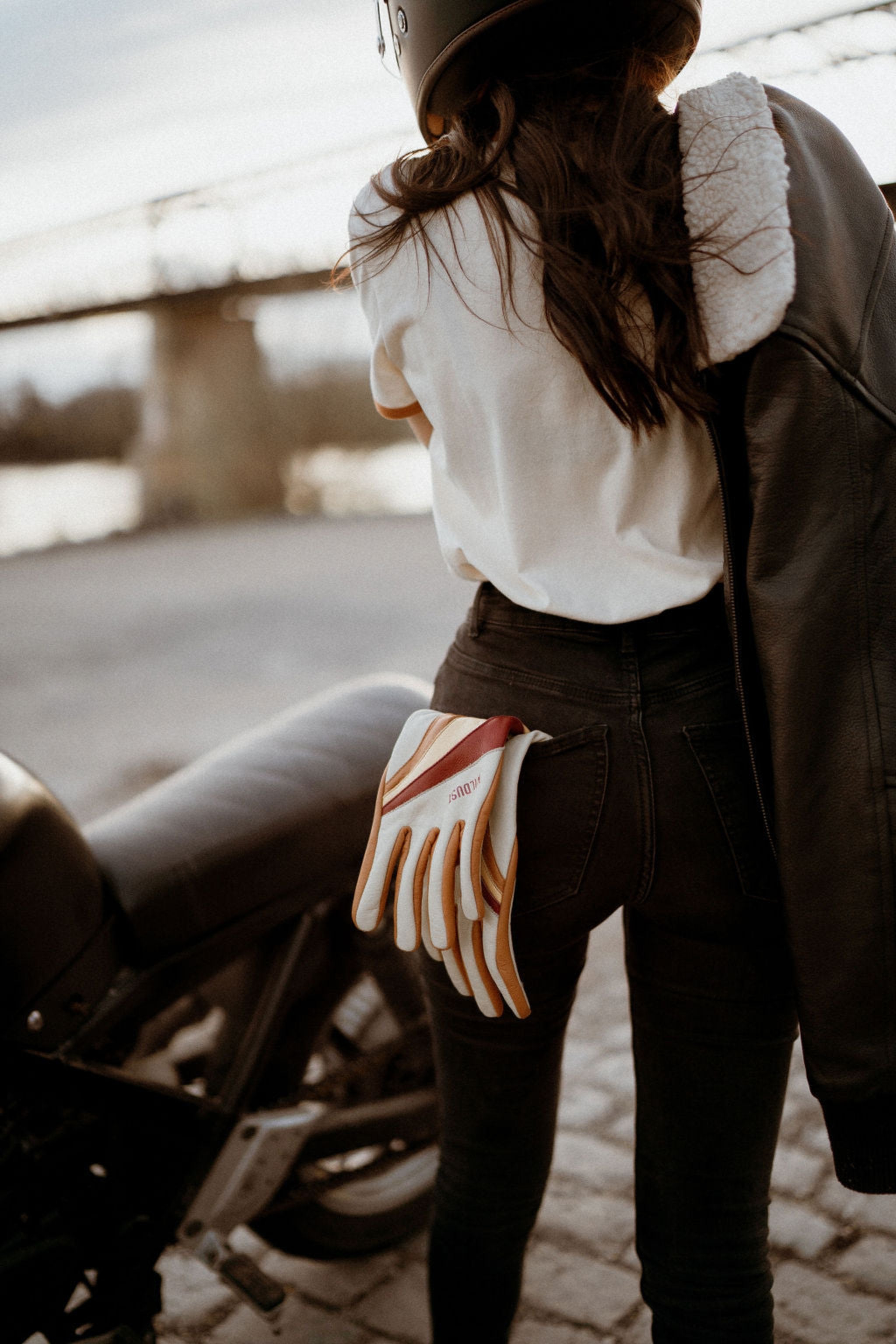  colourful leather motorcycle lady gloves from Wildust hanging from a woman&#39;s jeans back pocket