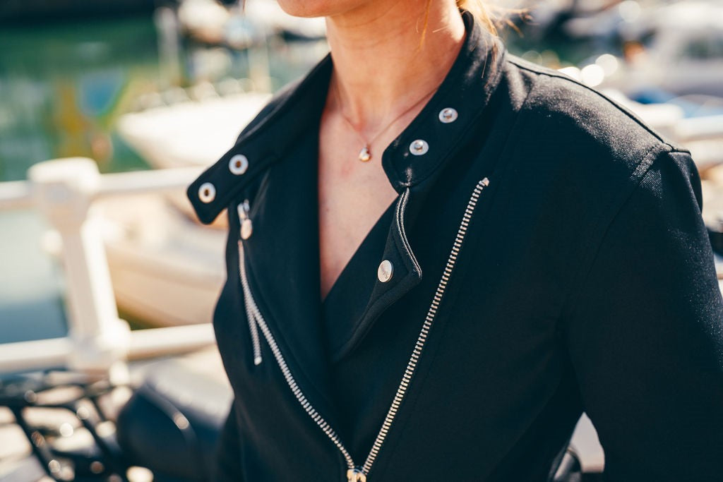 Person wearing a black leather jacket with a blurred background