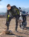 A woman closing her shoes wearing Black SHIMA touring motorcycle pants for women