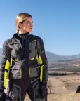 a. woman standing by her motorcycle wearing black fluo motorcycle lady jacket