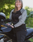 Woman standing next to a Kawasaki motorcycle with a blurred green background