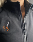 a close up of a woman's neck wearing black sweatshirt with a zip and MotoGirl embroidery 