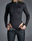 A woman putting her mc pants on wearing Armored motorcycle long-sleeve bodysuit base layer for women