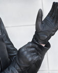 A woman putting on black female motorcycle gloves from Shima 