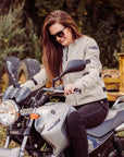 smiling woman sitting on a Yamaha motorcycle while wearing Jodie mesh mc jacket in natural from moto girl