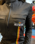 A close up of a woman's chest wearing black women's garage jumsuit with MotoGirl logo and stripe details