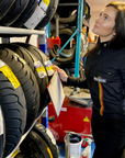 A woman wearing black garage suit for women from MotoGirl working in the motorcycle shop