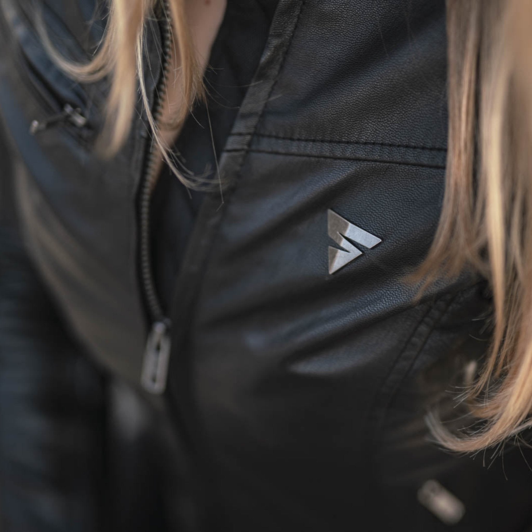 A close up of woman&#39;s chest wearing black motorcycle jacket