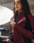 A young woman on her motorcycle wearing a red and black women's motorcycle jacket